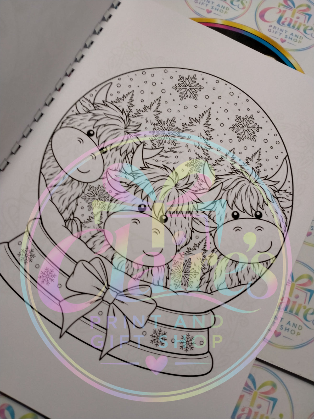 Three Highland cows in a festive snow globe colouring page